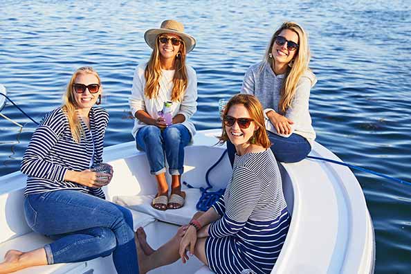 jenny tatelman and friends hanging on the bow of the boat