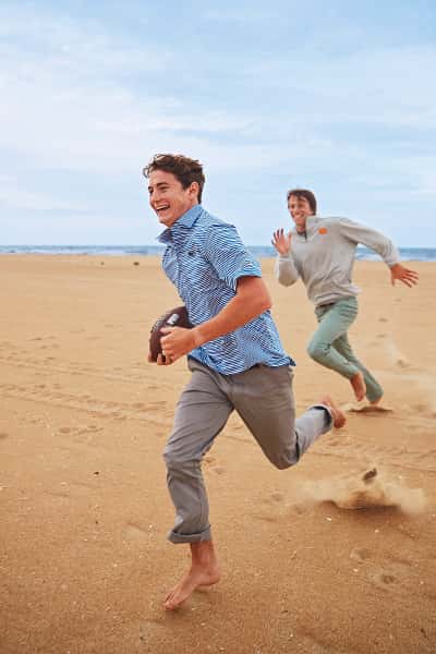 evan and daniel playing football on the beach