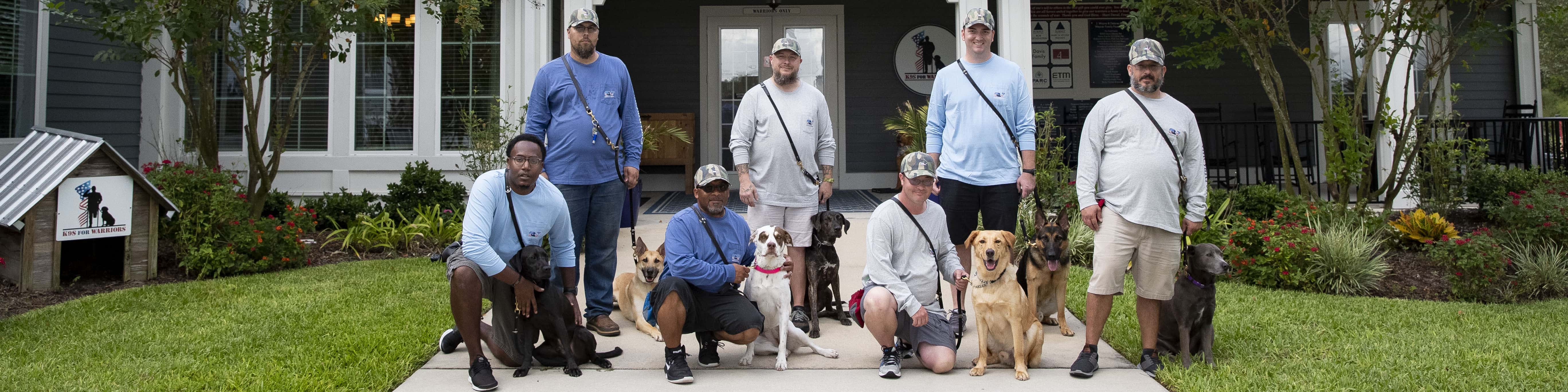 Veterans posing with their K9s